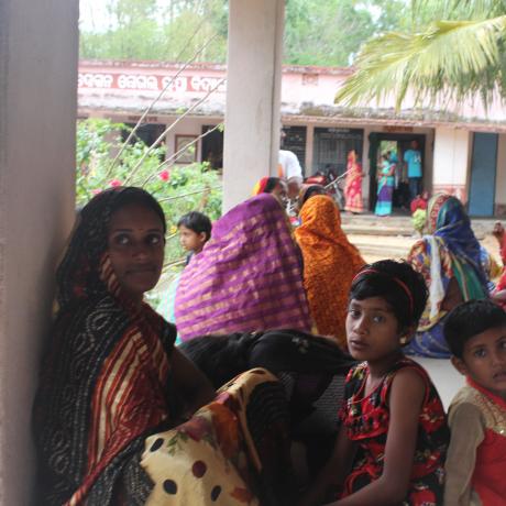 Families crouch outdoors in preparation of Cyclone Fani striking